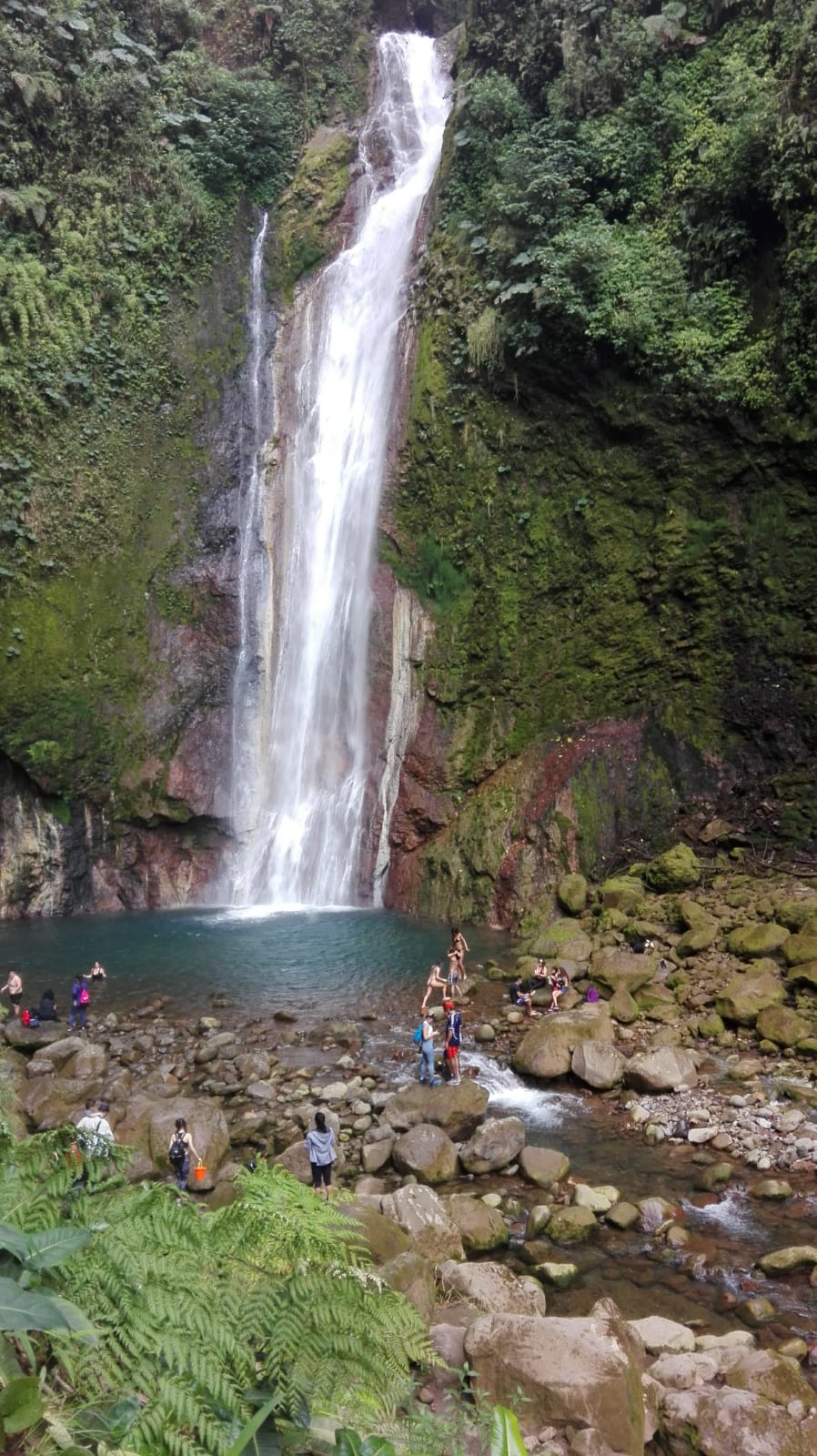 Poza al pie de la catarata con turistas