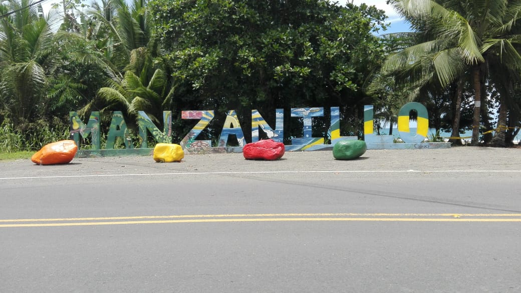 Letrero decorativo "MANZANILLO" con piedras pintadas de colores