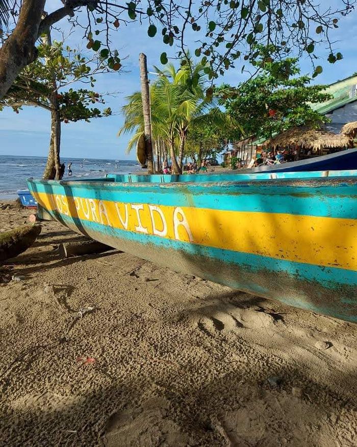 Bote para pescar colorido "Pura Vida" en la playa